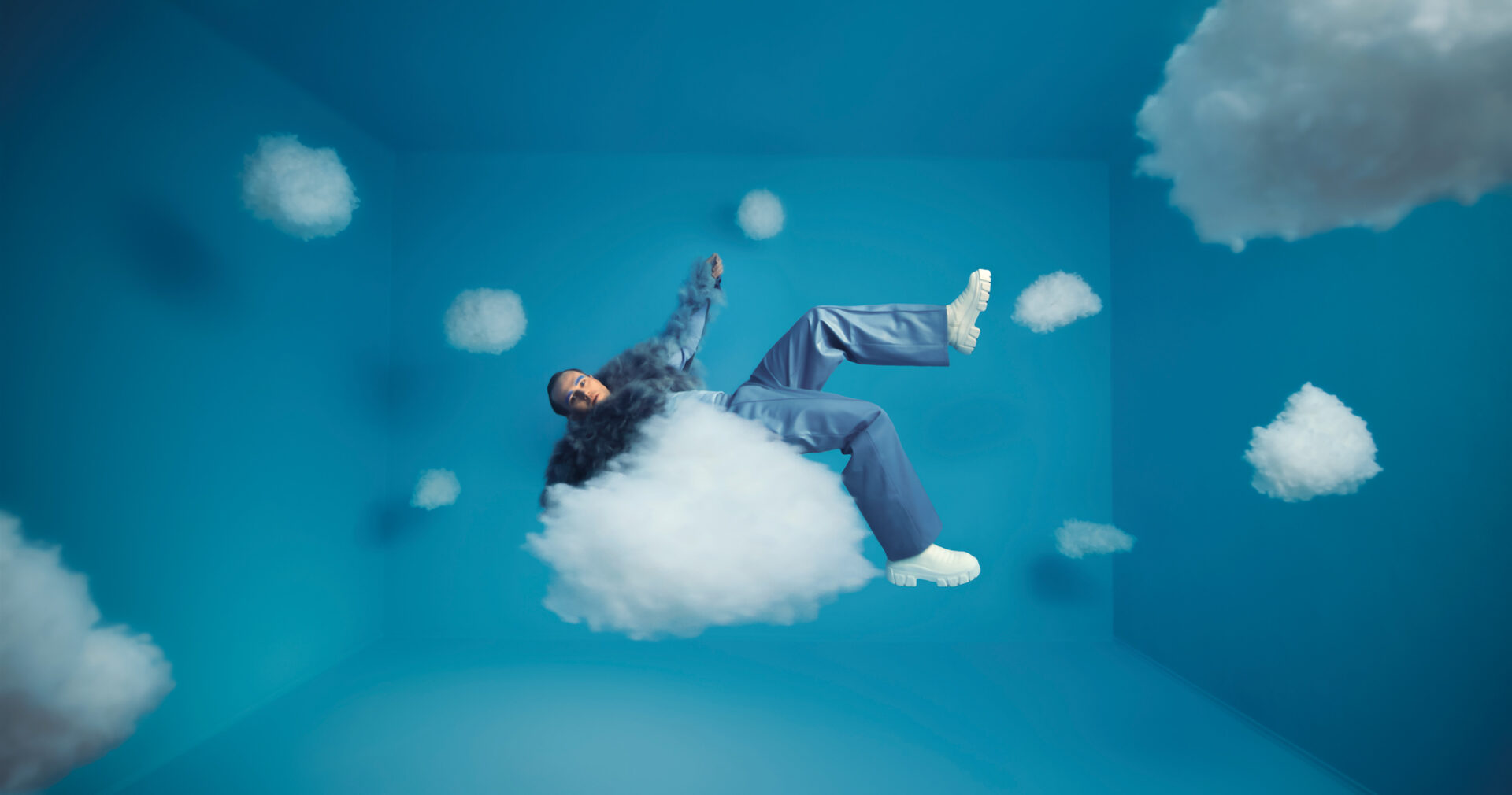 man floating in the blue sky on cloud nine